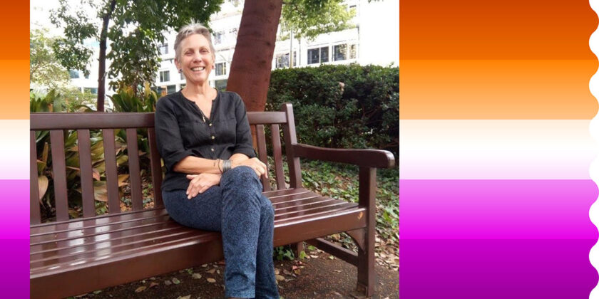 Lesbian Visibility Week image of Kedy sitting on a park bench smiling